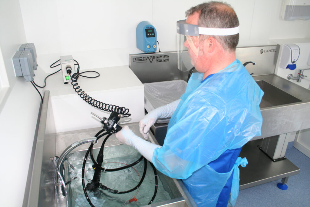Healthcare worker decontaminates endoscope